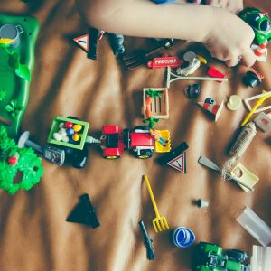 Children's hands playing with colorful toys on a mat, sparking creativity and fun.